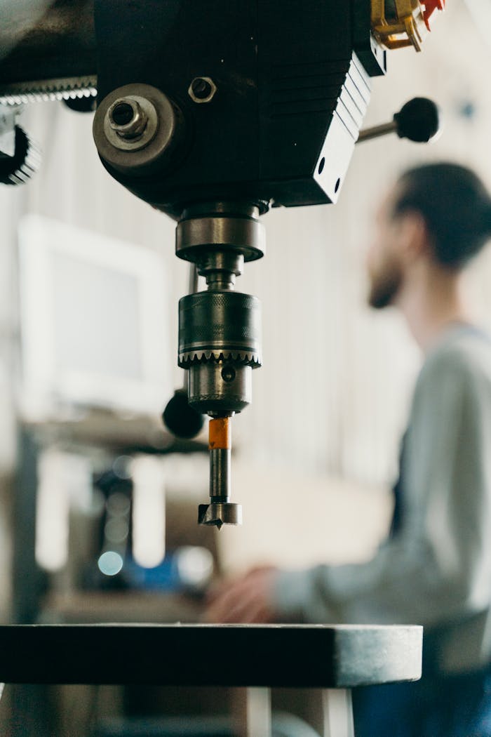 Detailed view of a drill machine in a workshop, with a blurred background.